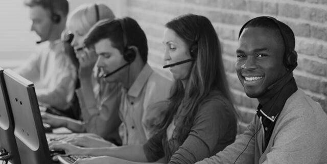 Customer service representatives on the computer and speaking on headsets